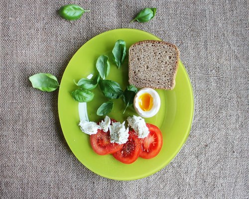 Freshly sliced avocados and vegetables arranged beautifully on a ceramic plate with warm soft textures